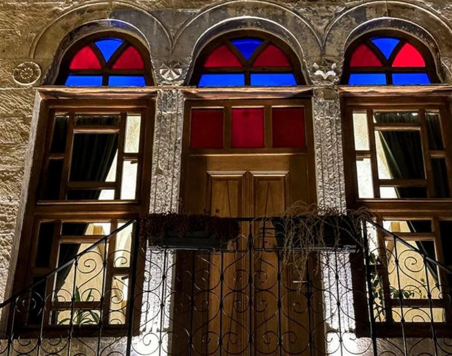 The same windows and door after restoration, lit at night